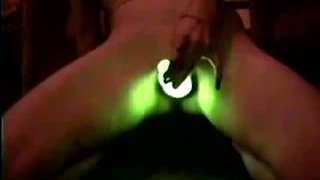 Slender white lady uses glowing stick for masturbation