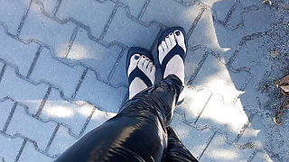 high platform flip flops and latex leggings in public