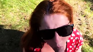 Kinky redhead with big tits gives a blowjob outdoors