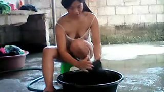 Asian girl doing laundry outdoors and teasing on webcam