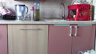 Sexy wife having fun in the kitchen with roses. Sexy naked wife preparing food in the kitchen.