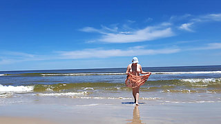 Amateur filming. A nudist plays with waves on the ocean shore.