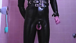 submissive rubber slave warms up it's ass and mouth before it's Master comes over
