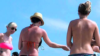 Playful nude beach girl caught on camera tanning