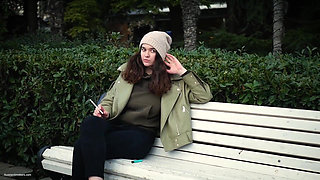 Young Brunette Is Taking an Unhurried Stroll with Allwhite 120mm Cigarette