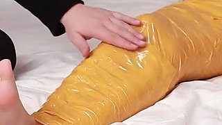 A Cute Barefoot Girlfriend Uses Tape to Bind Her Whole Body, Playing with Her Cute Bare Feet